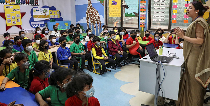 རྒྱ་གར་གྱི་སློབ་ཕྲུག་ཚོས་ཁ་ཤུབས་གྱོན་ནས་སློབ་ཚན་ལ་ཉན་བཞིན་པ།